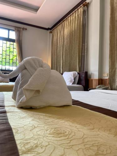 a towel animal sitting on a bed in a hotel room at Luang Prabang Inn 1 in Luang Prabang
