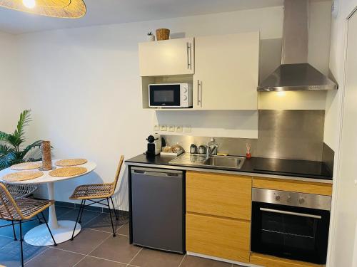 une cuisine avec un évier et une table avec des chaises dans l'établissement Apartment with beautiful terrace, à LʼIsle-sur-la-Sorgue