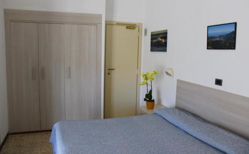 a bedroom with a blue bed and a closet at Hotel Puccinelli in Lido di Camaiore