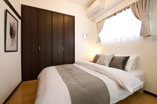 a bedroom with a large bed and a large window at Isole le Olena 601 in Naha