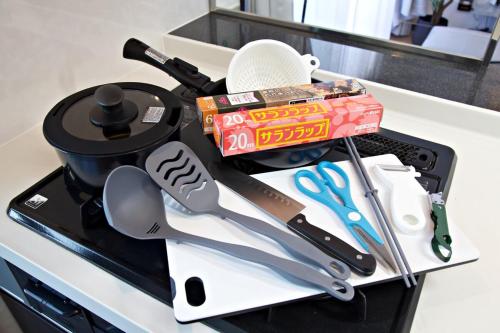 a tray with kitchen utensils on a counter at Isole le Olena 601 in Naha
