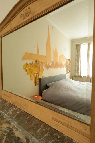 a bedroom with a large bed with a castle on the wall at In De Wulf in Ypres