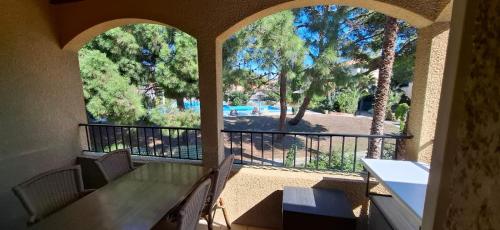 - une terrasse couverte avec une table et une vue sur la piscine dans l'établissement Duplex T3 climatisé, parking privé, WiFi, village vacances 6SIERRA223, à Canet