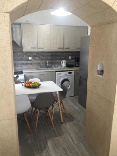 a kitchen with a table with a bowl of fruit on it at Denise House in Vromolithos