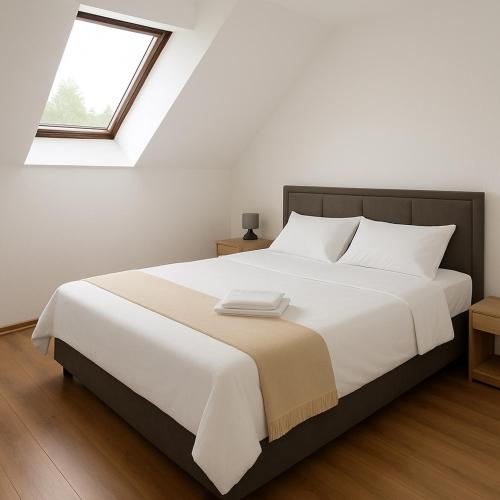 a bedroom with a large white bed with a window at Apartment and rooms D&J in Žabljak