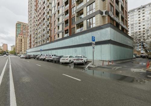 a parking lot with cars parked next to a building at Melissa Park Baku in Baku