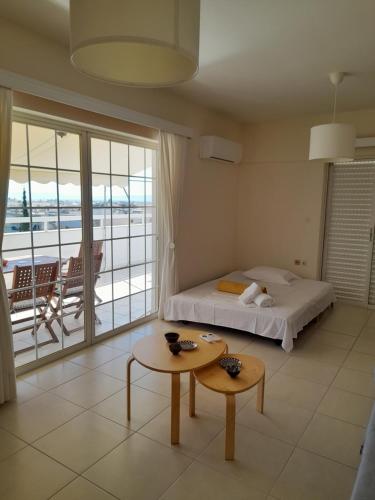 a bedroom with a bed and a table and a balcony at Kalamata 360 View in Kalamata