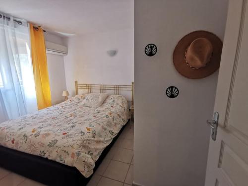 une chambre avec un lit et un chapeau au mur dans l'établissement Duplex T3 climatisé, parking privé, WiFi, village vacances 6SIERRA223, à Canet