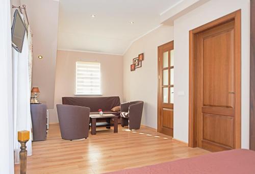 a living room with a table and chairs and a door at "Trakaitis" apartments & holiday homes in Trakai