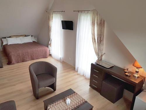 a bedroom with a desk and a bed and a chair at "Trakaitis" apartments & holiday homes in Trakai
