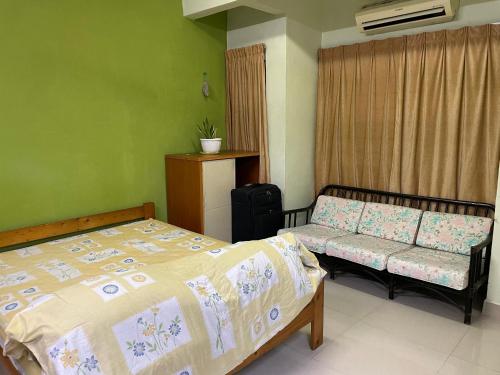 a bedroom with a bed and a couch at Spacious Double Storey House in Bandar Country Homes, Rawang, Ideal for families or working professionals seeking comfort, convenience and a quiet place to call home in Kampung Tumbuk Pantai