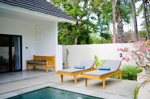 a patio with two chairs and a pool at Lush Tropical Villa Central Amed in Amed
