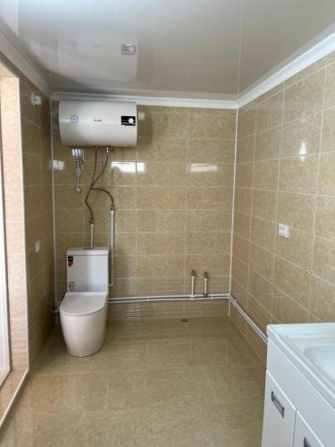 a bathroom with a toilet and a sink at Гостевой дом in Akchiy