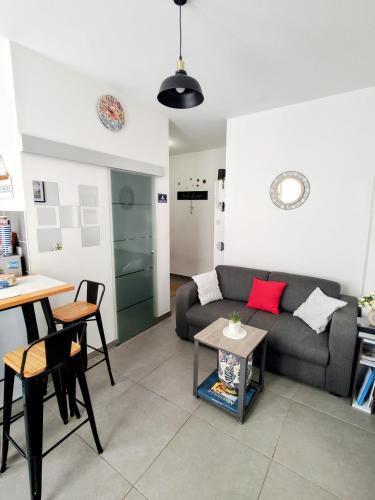 un salon avec un canapé et une table dans l'établissement Studio coin nuit, Entre plage et centre, à Marseille