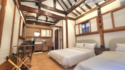 a bedroom with two beds and a desk in it at HAEMIL Hanok in Seoul