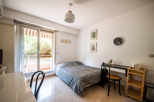 une chambre avec un lit, un bureau et une fenêtre dans l'établissement Studio au plein coeur de Nice, à Nice