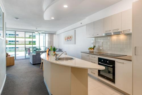 a kitchen with white cabinets and a counter top at Cilento Mooloolaba in Mooloolaba