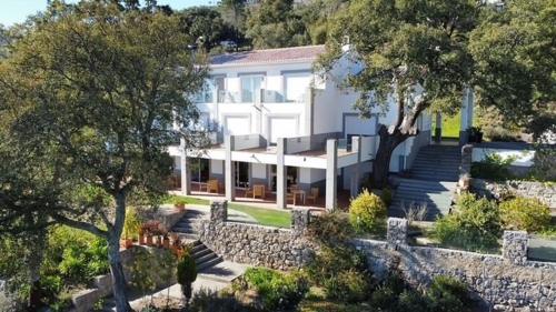 a large white building with a stone wall at VilaFoia in Monchique