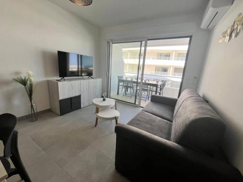 un salon avec un canapé, une télévision et une table dans l'établissement Panaréa Cieu, à Valras-Plage