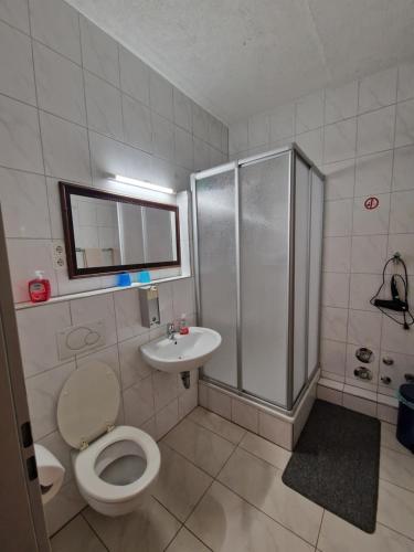 a bathroom with a shower and a toilet and a sink at Pension Antalya in Friedrichshafen