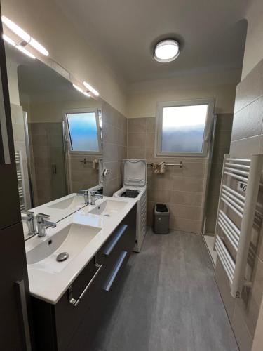 ein Badezimmer mit zwei Waschbecken und einem großen Spiegel in der Unterkunft Maison T4 plain pied climatisée avec une belle terrasse ombragée 6AVR44 in Canet-en-Roussillon