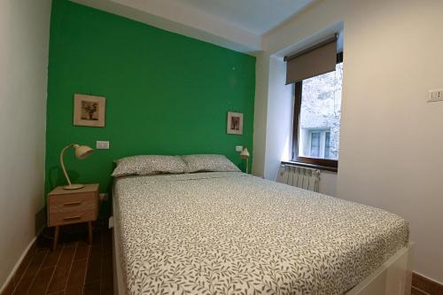 a bedroom with a bed and a green wall at La Casa del Nocciolo in Capranica