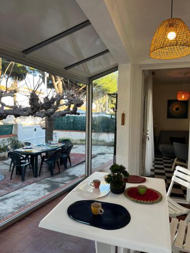 ein Wohnzimmer mit Tisch und ein Esszimmer in der Unterkunft Maison T4 plain pied climatisée avec une belle terrasse ombragée 6AVR44 in Canet-en-Roussillon