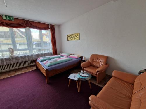 a room with a bed and a couch and a chair at Pension Antalya in Friedrichshafen