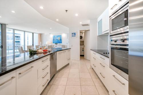 a large white kitchen with white cabinets and appliances at Cilento Mooloolaba in Mooloolaba