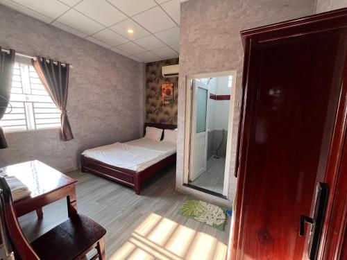 a small room with a bed and a mirror at Trung Hau Hotel in Can Tho