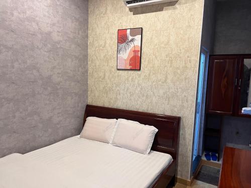 a bedroom with two beds and a picture on the wall at Trung Hau Hotel in Can Tho