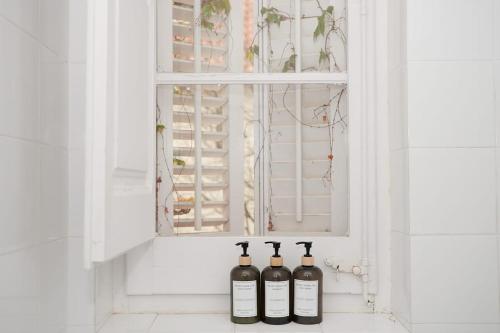 Tres botellas de vino en una ventana en Hotel restaurant Xalet la Coromina, en Viladrau