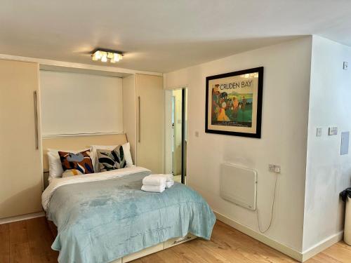 a bedroom with a bed and a picture on the wall at Studio Close to Excel Centre in London