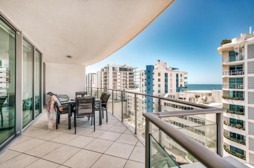 a balcony with a table and chairs and the ocean at Cilento Mooloolaba in Mooloolaba