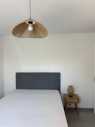 une chambre avec un lit blanc et une lampe dans l'établissement Appartement dans résidence 3 étoiles, à Porto-Vecchio