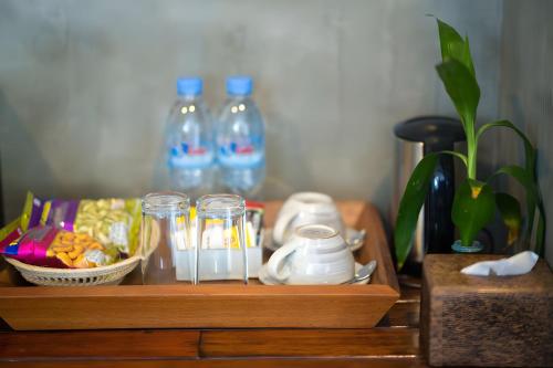 a wooden table with a tray of food and glass bottles at Vihara The City of Temples in Siem Reap