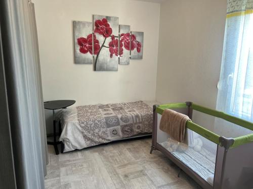 - une chambre avec un lit orné de fleurs rouges sur le mur dans l'établissement Appartement vue château, à Carcassonne