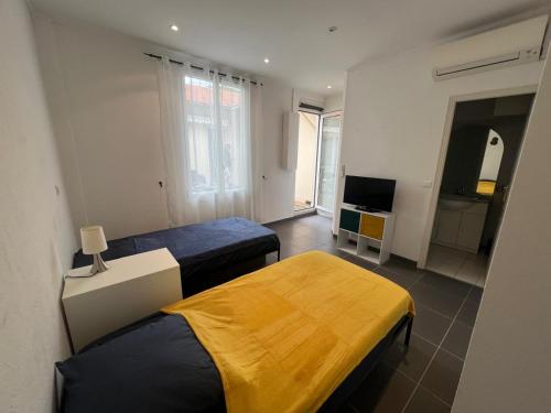 une chambre d'hôtel avec deux lits et une télévision dans l'établissement Appartement Cannes 3P, terrasse, garage, à Cannes