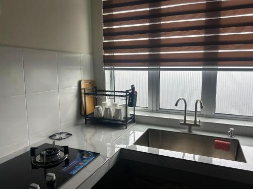 a kitchen with a sink and a window at iHomie Suites - Homestay Kulim in Kulim