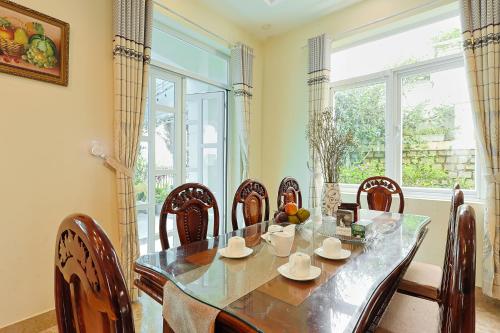 une salle à manger avec une table et des chaises et une fenêtre dans l'établissement The Hill Villa - Đà Lạt, à Xuan An