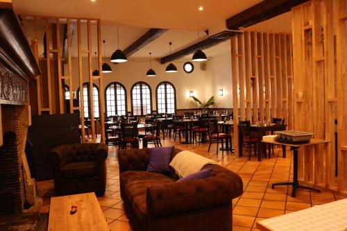 un salon avec des canapés et des tables ainsi qu'un restaurant dans l'établissement Hotel Le D'artagnan, à Vic-Fezensac