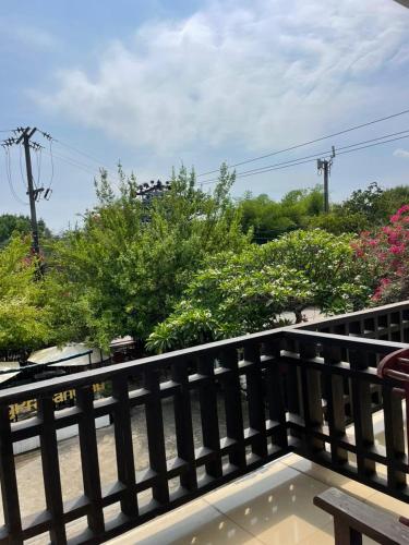 a balcony with a bench and some bushes and trees at Luang Prabang Inn 1 in Luang Prabang