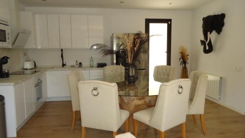 a kitchen with a table and chairs in a kitchen at Villa Romeo in Sant Jordi