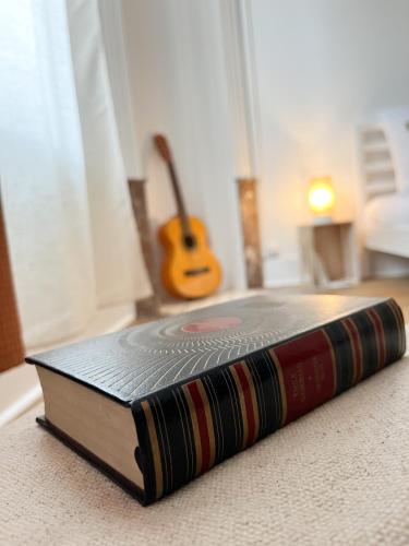a book sitting on the floor next to a guitar at Le Refuge, Pet friendly, Free Parking in Pagny-sur-Moselle