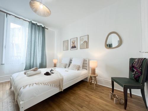a white bedroom with a bed and a green chair at Le Refuge, Pet friendly, Free Parking in Pagny-sur-Moselle