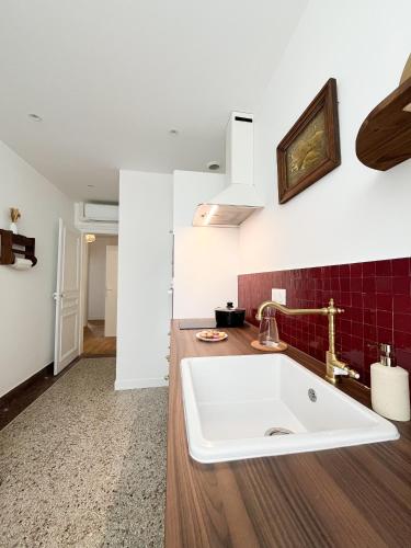 a kitchen with a white sink and red tiles at Le Refuge, Pet friendly, Free Parking in Pagny-sur-Moselle