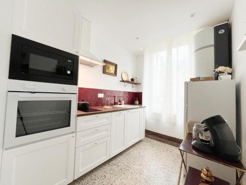 a kitchen with white cabinets and a microwave at Le Refuge, Pet friendly, Free Parking in Pagny-sur-Moselle