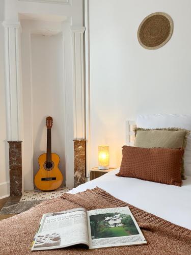 a bedroom with a bed with a book and a guitar at Le Refuge, Pet friendly, Free Parking in Pagny-sur-Moselle