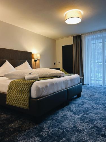 a bedroom with a large bed with a large window at Apart Peppone in Längenfeld