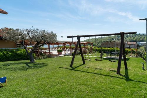a park with a swing set in the grass at La Collinetta Residence in Persano